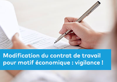 Une image en gros plan d’une main signant un contrat sur une table en bois, avec un stylo élégant et des documents officiels en arrière-plan, représentant les enjeux juridiques et économiques des modifications contractuelles.