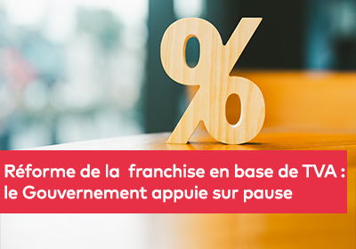 Signe de pourcentage en bois posé sur une table, avec un fond flou en intérieur