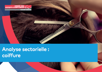 Gros plan sur une coupe de cheveux en cours de réalisation, avec des ciseaux crantés et un peigne dans une chevelure brune.