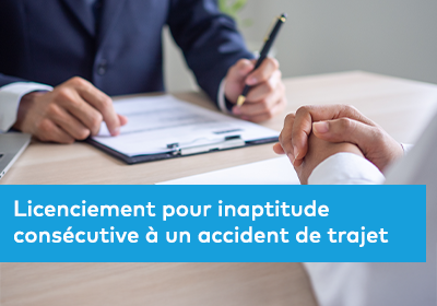 Deux personnes discutent autour d’un bureau, l’une tenant un stylo au-dessus d’un document.