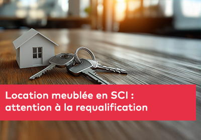 Une petite maison miniature posée sur une table en bois, accompagnée de plusieurs clés métalliques.