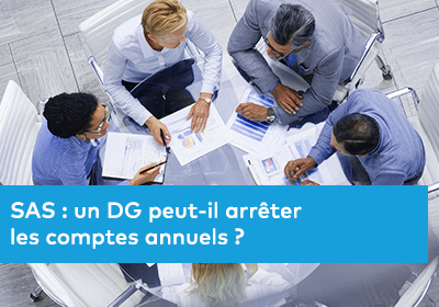 Plusieurs personnes réunies autour d’une table analysent ensemble des documents et graphiques lors d’une réunion professionnelle.